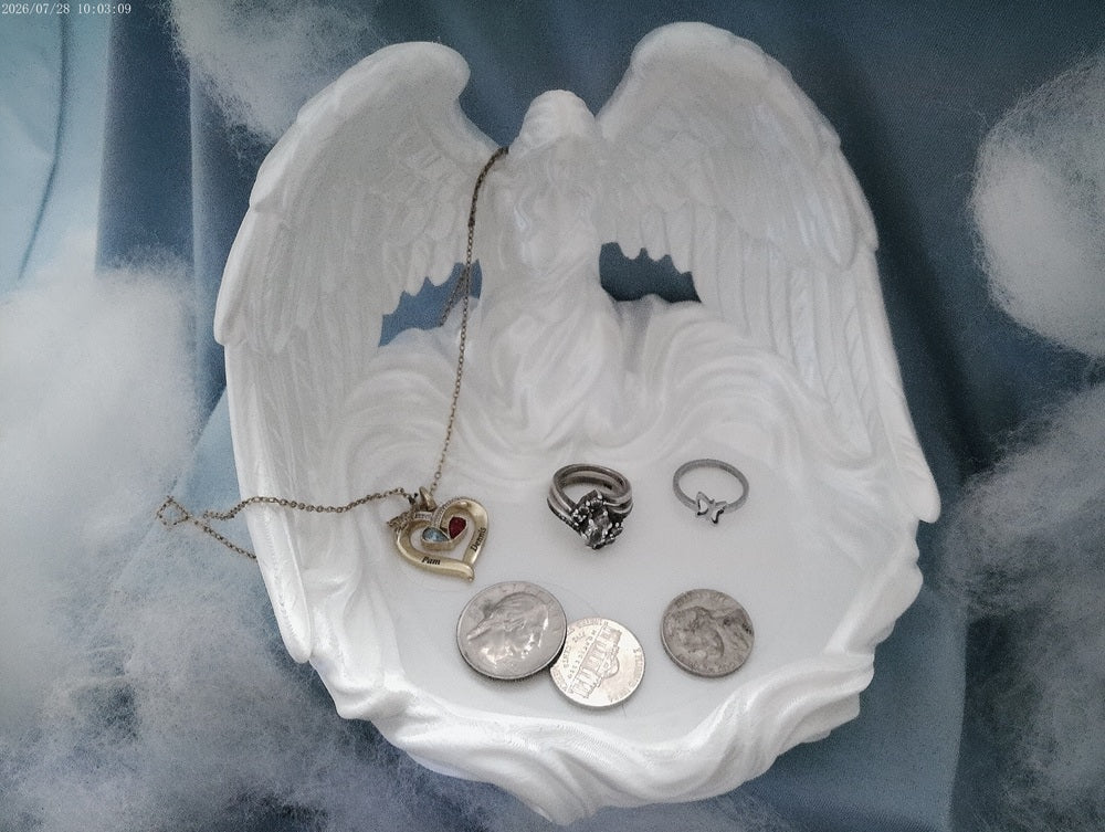 Angel wings trinket tray in silk white PLA with jewelry and coins displayed inside, on a blue cloudy backdrop
