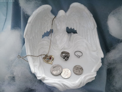 Angel wings trinket tray in silk white PLA with jewelry and coins displayed inside, on a blue cloudy backdrop