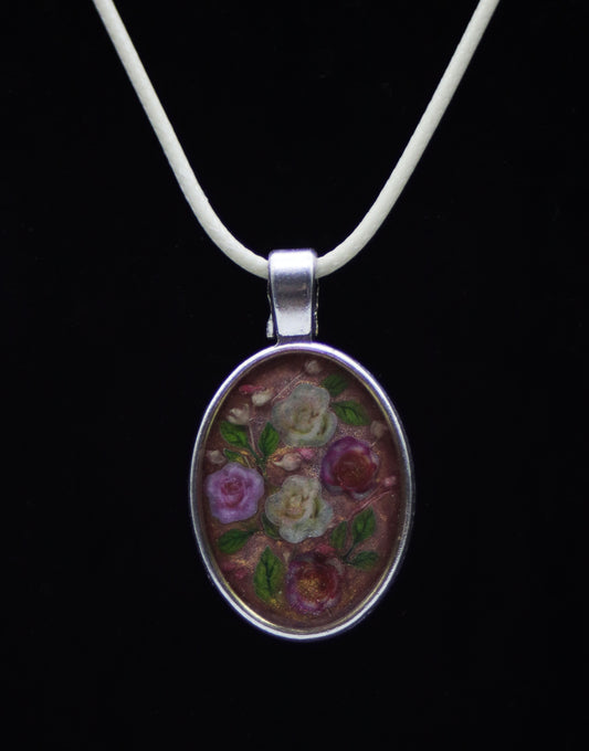 Silver oval resin necklace with wood flower roses in purple, cream, and red on ivory cord