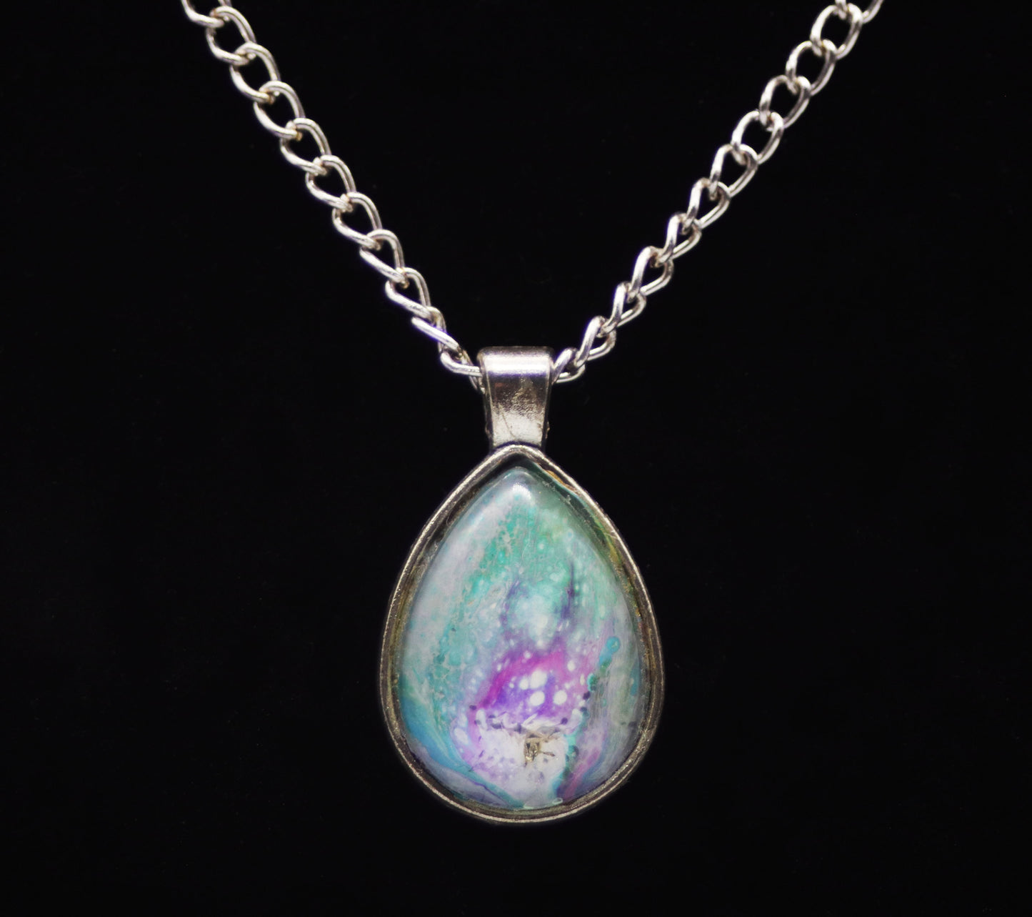 Silver teardrop necklace with glass cabochon over teal purple lavender white swirl paint skin