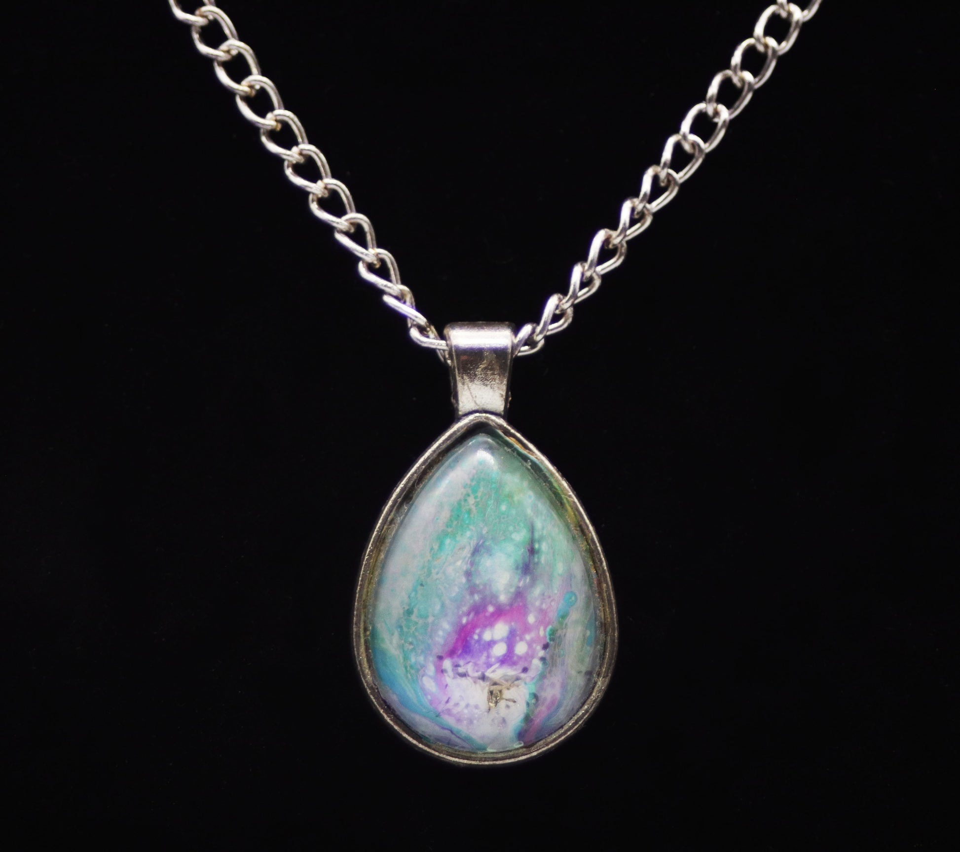 Silver teardrop necklace with glass cabochon over teal purple lavender white swirl paint skin