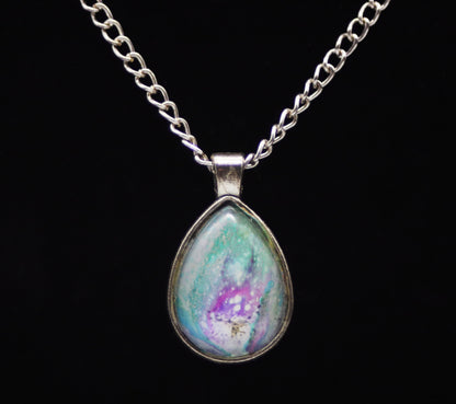 Silver teardrop necklace with glass cabochon over teal purple lavender white swirl paint skin