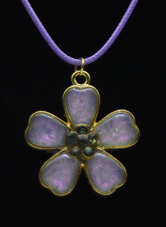 Gold five-petal flower necklace with lavender resin petals and dark teal bead center on lavender cord